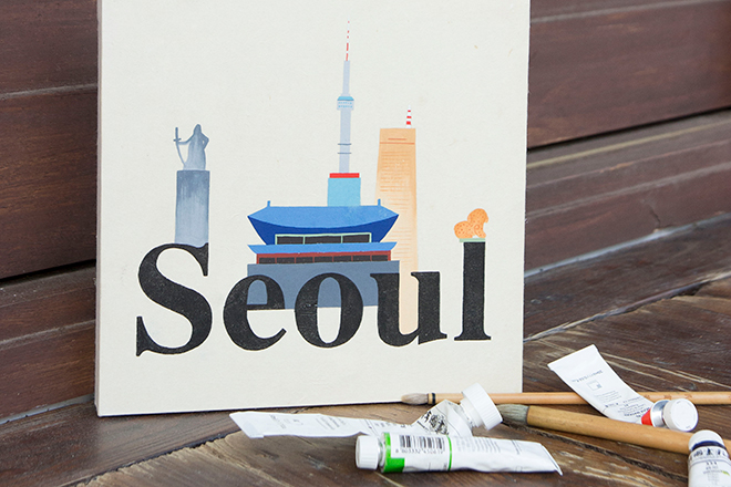 캔버스에 물감으로 서울의 랜드마크와 Seoul 글씨가 그려져있음