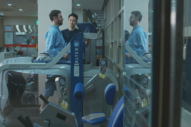 Photo of a therapist and patient undergoing rehabilitation on a treadmill